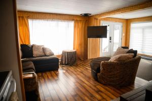 a living room with a couch and a tv at Upper Floor - Mont-Video in Barraute