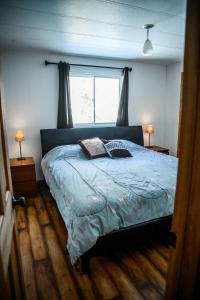 a bedroom with a bed with a blue comforter and a window at Upper Floor - Mont-Video in Barraute