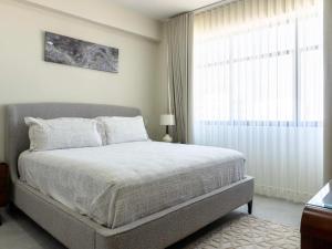 a bedroom with a bed and a large window at Rooftop Pool & Steps to the Beach in Mazatlán
