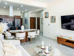 a living room with a white couch and a table at Rooftop Pool & Steps to the Beach in Mazatlán