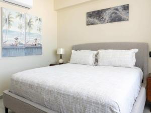 a bedroom with a white bed and palm trees at Rooftop Pool & Steps to the Beach in Mazatlán +33 photos