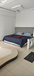 a bedroom with a bed with blue sheets and red pillows at Dar Essaada - Exceptionel duplex de 270 M2, plage à 2 min à pieds in Mahdia