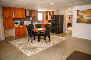 a kitchen with a table and chairs and a refrigerator at Lower Floor - Mont-Video in Barraute