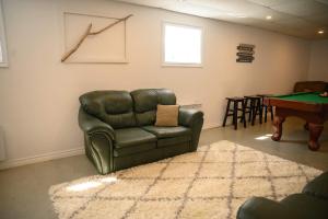 a living room with a leather couch and a pool table at Lower Floor - Mont-Video in Barraute +28 photos