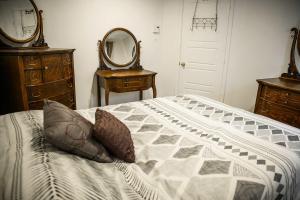 a bedroom with a bed and a dresser and a mirror at Lower Floor - Mont-Video in Barraute