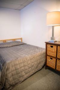 a bedroom with a bed and a lamp on a dresser at Lower Floor - Mont-Video in Barraute