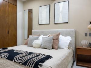 a bedroom with a bed with pillows on it at Sunset Rooftop Pool Near the Beach in Mazatlán