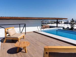 a patio with a chair and a pool on a roof at Sunset Rooftop Pool Near the Beach in Mazatlán +34 photos