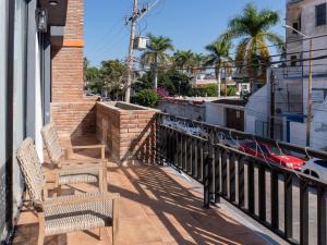 two chairs sitting on a balcony with a view of a street at Sunset Rooftop Pool Near the Beach in Mazatlán
