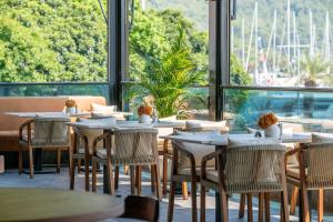 a restaurant with tables and chairs and a large window at Skopea Inn Exclusive Hotel in Göcek