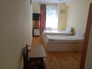 a small room with two beds and a table at NR Rest House in Tsaghkadzor