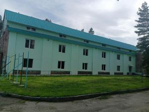 a large white building with a blue roof at NR Rest House in Tsaghkadzor +16 photos