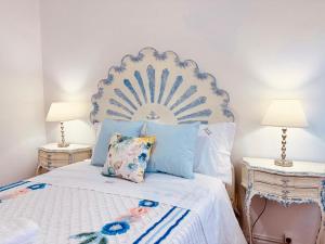 a bedroom with a white bed with blue pillows at Casa da Pontelha VILLA INN in Ponte de Lima