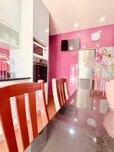 a kitchen with a dining table and a purple wall at Casa da Pontelha VILLA INN in Ponte de Lima +28 photos