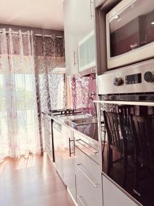 a kitchen with a stove and a microwave at Casa da Pontelha VILLA INN in Ponte de Lima