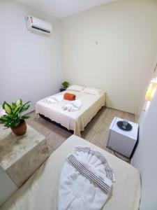 a small room with two beds and a table at Pousada Aconchego em Mundaú in Trairi