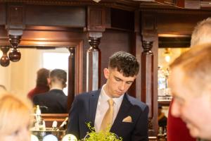 a man in a suit and yellow tie at Viking House Hotel Donegal in Kincasslagh