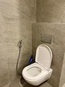 a white toilet in a bathroom with a shower at Veloria Grand Suites in Greater Noida +10 photos