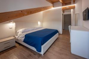a bedroom with a large bed with a blue blanket at Cilento Sea Rooms in Agropoli +9 photos