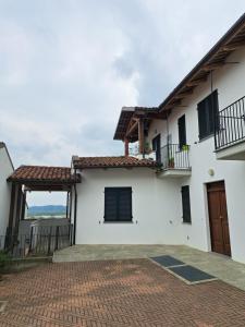 a white house with a brick driveway at Maison Bon Ton in Villafranca dʼAsti