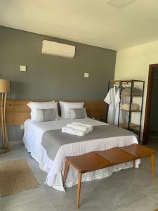 a bedroom with a large bed and a shelf at Chalé Village da Serra in Serra de São Bento