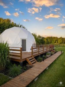 a white tent sitting on a wooden bridge at Glamping LA BELLA Suntago in Aleksandria
