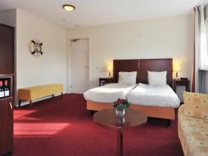 een hotelkamer met een bed en een bank bij de Brabantse Biesbosch in Werkendam