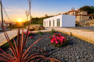 a white house with flowers in a gravel yard at Douro Garden in Resende