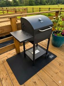 a grill on a deck with a laptop computer on it at Glamping LA BELLA Suntago in Aleksandria
