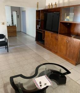 a living room with a tv and a glass table at Habitación 4 in Asunción