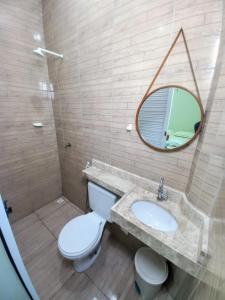 a bathroom with a toilet and a sink and a mirror at Pousada Aconchego em Mundaú in Trairi +20 photos