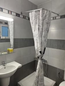 a bathroom with a sink and a shower curtain at ERODIOS apartments in Karistos +45 photos