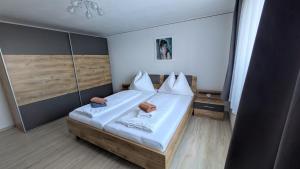 a small bedroom with a bed with white sheets at Am Heißberg in Fehring