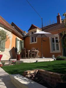 a backyard with an umbrella and a table and chairs at Villa Ô bedroom 1 in Chasnay