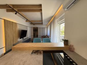 a living room with a table and blue chairs at Bright Apartment with Balcony near Bus and Train in Mostar