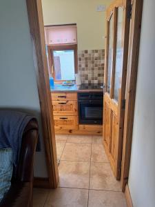 a kitchen with a wooden cabinet and a window at Kathleen’s Haven in Causeway