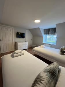a bedroom with two beds and a tv on the wall at Craig Cottage in Banff