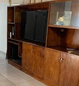 a large wooden entertainment center with a flat screen tv at Habitación 4 in Asunción