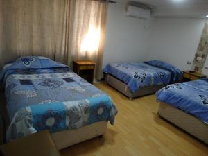 a hotel room with two beds and a table at hotel rancagua in Rancagua