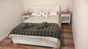 a bedroom with a bed with two pillows on it at Principality Apartment in Cardiff