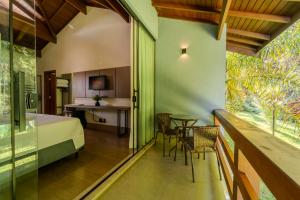 a room with a bed and a table and chairs at Pousada Saint Diniz in Monte Sião
