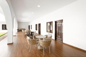 a dining room with tables and chairs and white walls at Hotel H4 El Paraíso in El Paraíso