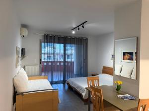 a bedroom with a bed and a table with a dining room at ERODIOS apartments in Karistos