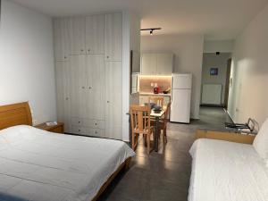 a bedroom with a bed and a kitchen with a table at ERODIOS apartments in Karistos