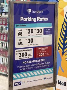 a sign for parking rates in a store at MDM Staycation by SMDC in Manila