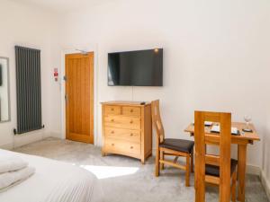 a bedroom with a desk and a tv on a wall at Lumsdale in Matlock