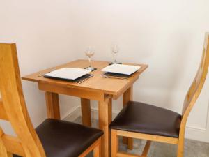a wooden table with two glasses and two chairs at Lumsdale in Matlock +9 photos
