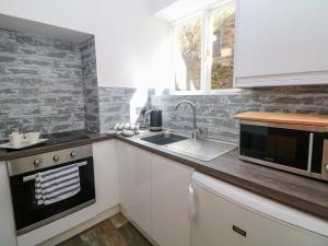 a kitchen with a sink and a microwave at Lumsdale in Matlock