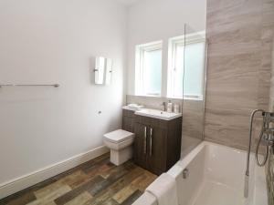 a bathroom with a tub and a toilet and a sink at Lumsdale in Matlock