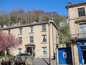 an old stone building with a blue door on a street at Lumsdale in Matlock